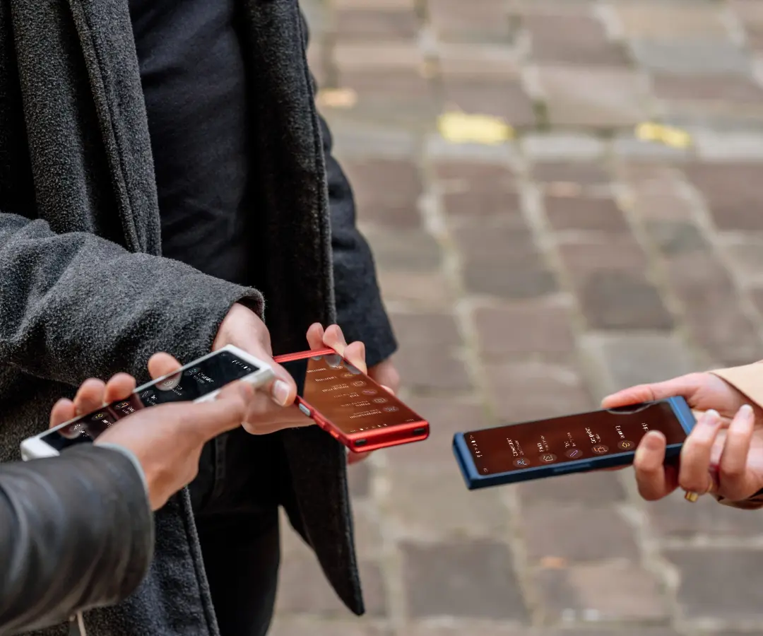 Três amigos que seguram alegremente os seus tradutores, empenhados em conversas e partilham momentos juntos. 